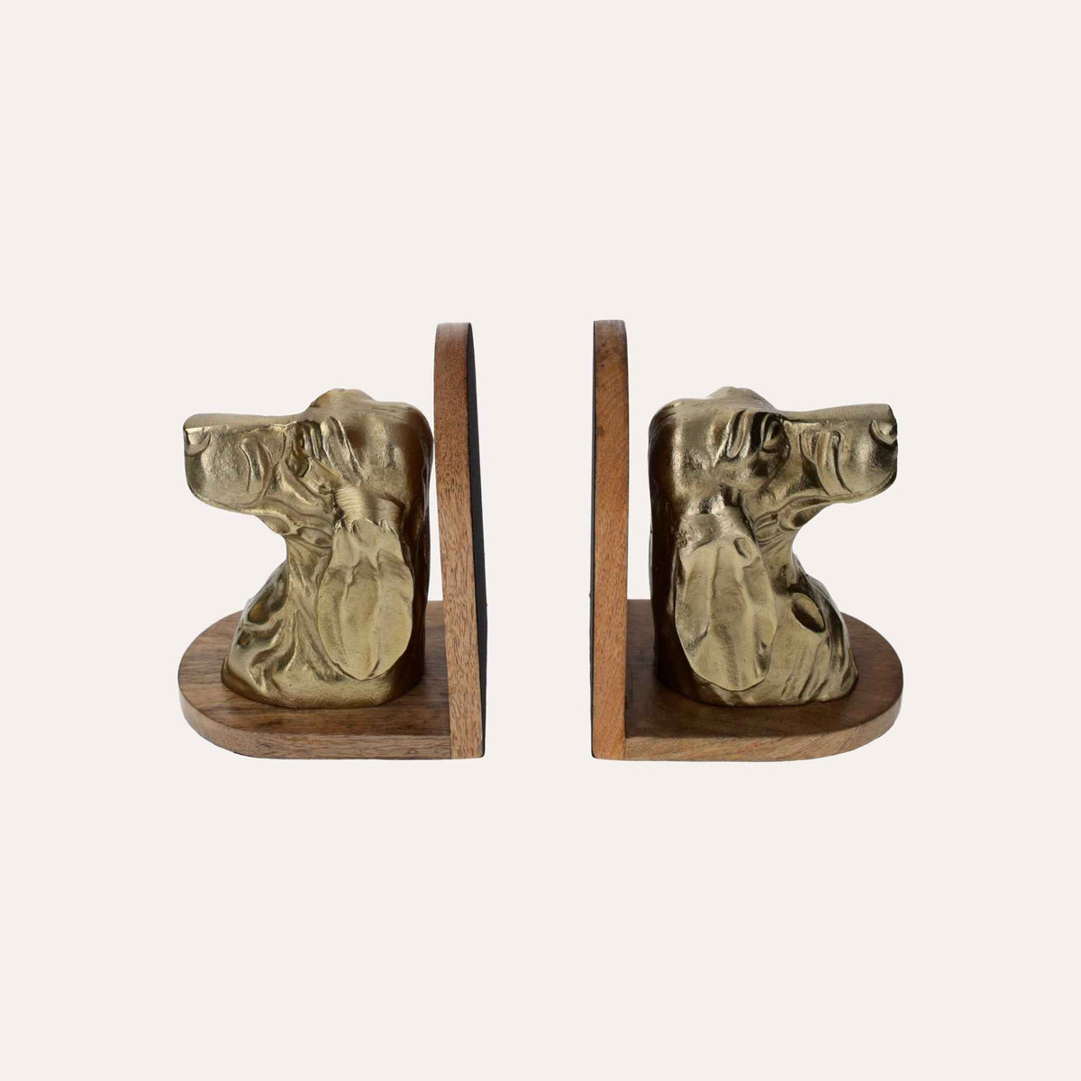 Sujetalibros con forma de busto de perro de metal dorado sobre soporte de madera